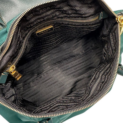interno Borsa Prada in nylon color ottanio con finiture in pelle tono su tono e parti metalliche dorate; munita di doppi manici stondati e una tracolla amovibile e regolabile. Completa di dustbag, di lusso, originale, ottime condizioni. 