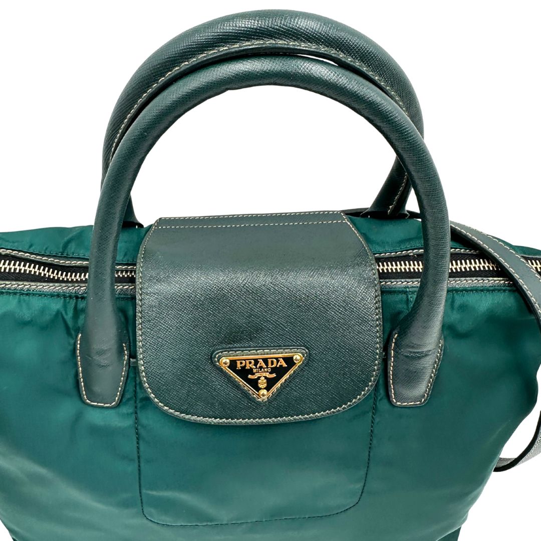 manici Borsa Prada in nylon color ottanio con finiture in pelle tono su tono e parti metalliche dorate; munita di doppi manici stondati e una tracolla amovibile e regolabile. Completa di dustbag, di lusso, originale, ottime condizioni. 