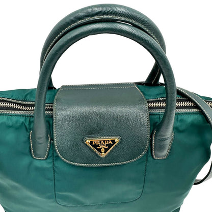 manici Borsa Prada in nylon color ottanio con finiture in pelle tono su tono e parti metalliche dorate; munita di doppi manici stondati e una tracolla amovibile e regolabile. Completa di dustbag, di lusso, originale, ottime condizioni. 