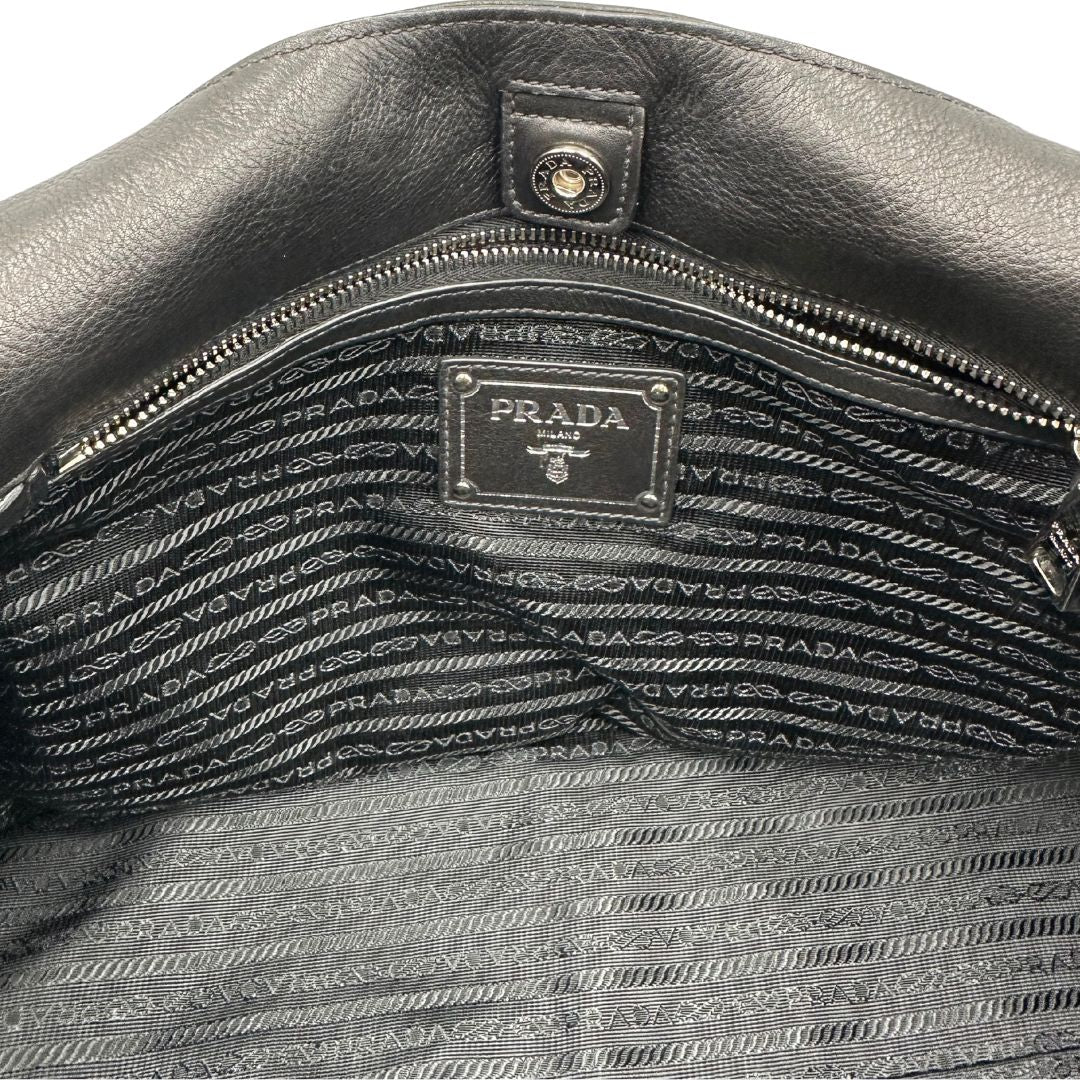 interno Borsa Prada in pelle nera con parti metalliche argentate; munita di doppi manici in pelle e catena intrecciati, da portare a spalla, di lusso, originale, ottime condizioni, usata.