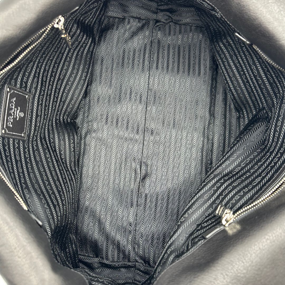 interno Borsa Prada in pelle nera con parti metalliche argentate; munita di doppi manici in pelle e catena intrecciati, da portare a spalla, di lusso, originale, ottime condizioni, usata.