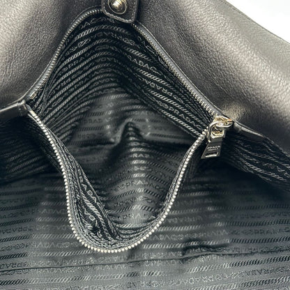interno Borsa Prada in pelle nera con parti metalliche argentate; munita di doppi manici in pelle e catena intrecciati, da portare a spalla, di lusso, originale, ottime condizioni, usata.