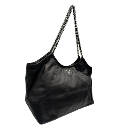 lato Borsa Prada in pelle nera con parti metalliche argentate; munita di doppi manici in pelle e catena intrecciati, da portare a spalla, di lusso, originale, ottime condizioni, usata.