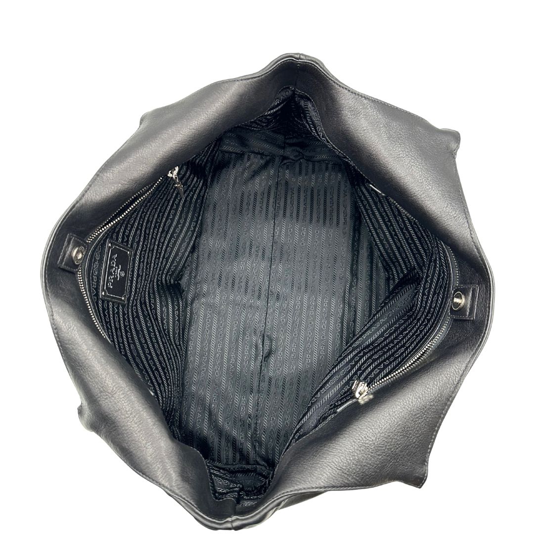 interno Borsa Prada in pelle nera con parti metalliche argentate; munita di doppi manici in pelle e catena intrecciati, da portare a spalla, di lusso, originale, ottime condizioni, usata. 