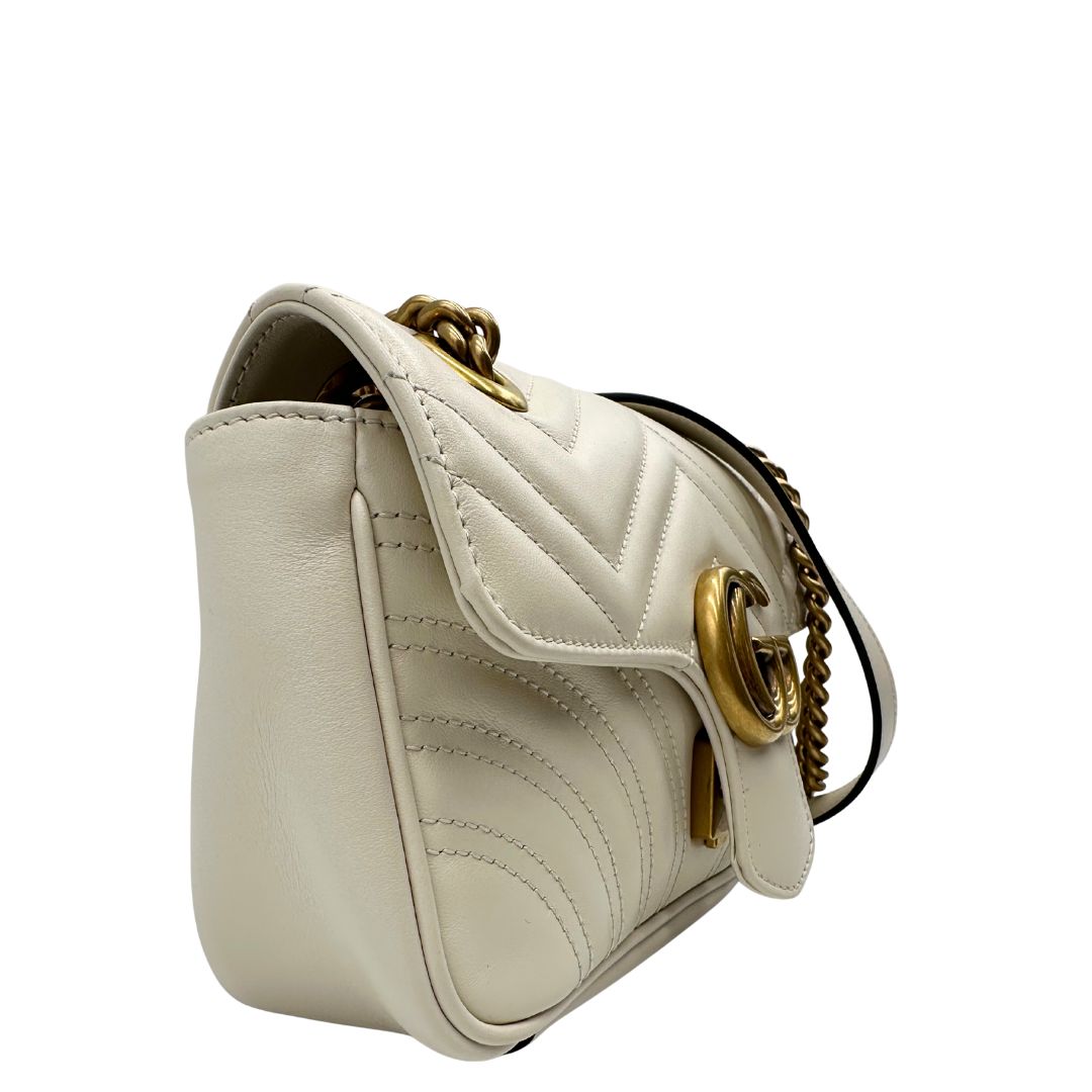 lato Borsa Gucci Marmont in pelle bianca con parti metalliche dorate; munita di una tracolla in catena con spallaccio in pelle. Full set, di lusso, originale, ottime condizioni. 
