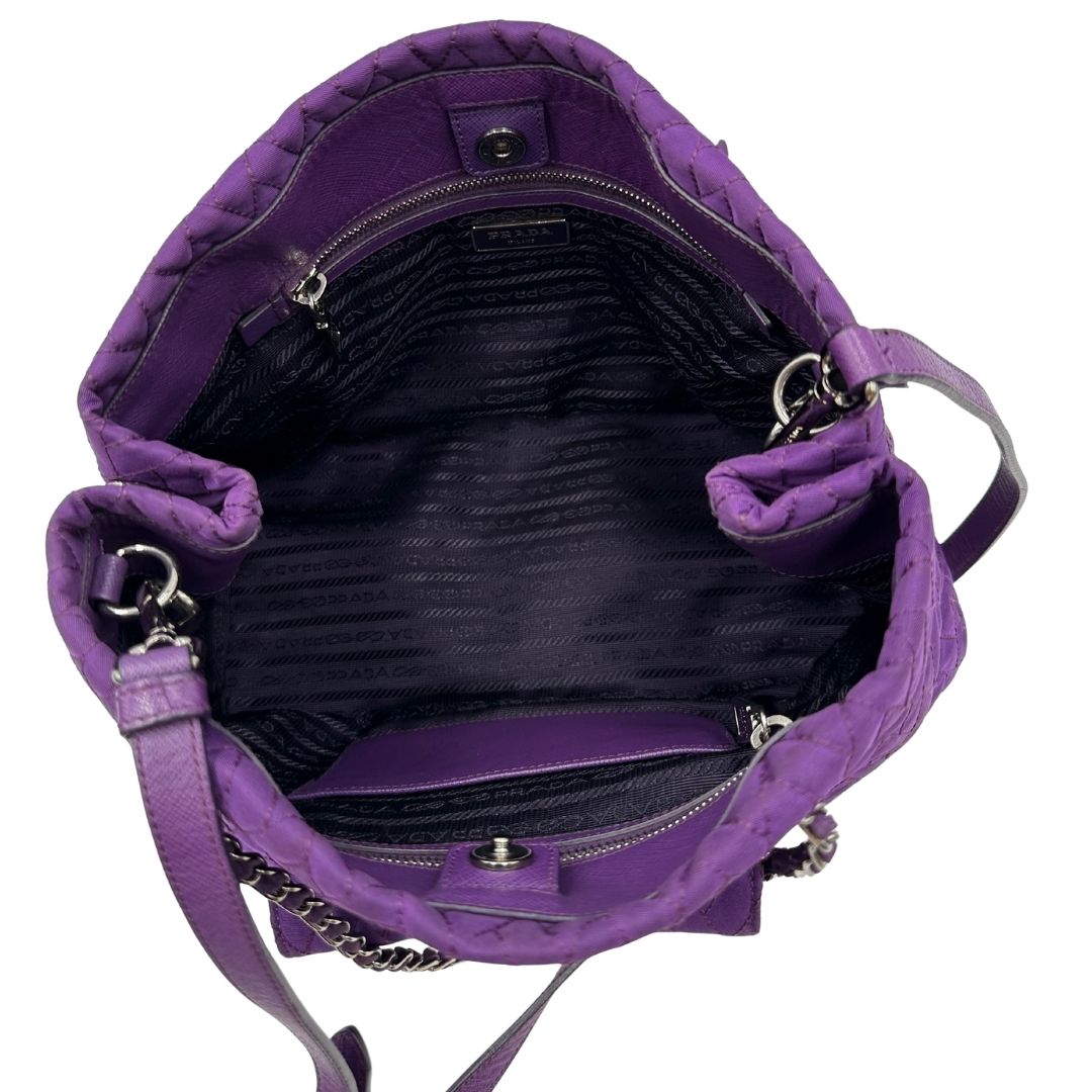 interno Borsa Prada in nylon viola con finiture in pelle tono su tono e parti metalliche argentate; munita di doppi manici in catena e pelle intrecciati e una tracolla amovibile e regolabile. Completa di dustbag, di lusso, originale, ottime condizioni, usata, originale.