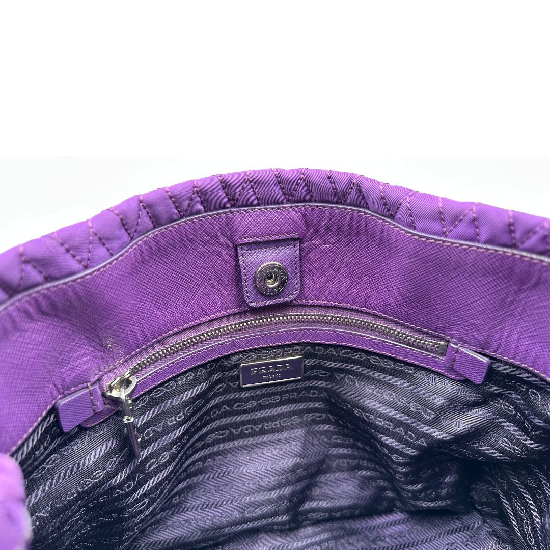 chiusura Borsa Prada in nylon viola con finiture in pelle tono su tono e parti metalliche argentate; munita di doppi manici in catena e pelle intrecciati e una tracolla amovibile e regolabile. Completa di dustbag, di lusso, originale, ottime condizioni, usata, originale.