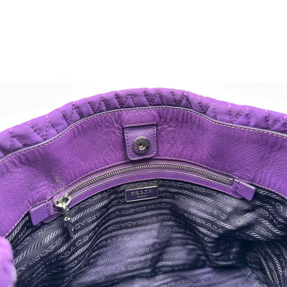 chiusura Borsa Prada in nylon viola con finiture in pelle tono su tono e parti metalliche argentate; munita di doppi manici in catena e pelle intrecciati e una tracolla amovibile e regolabile. Completa di dustbag, di lusso, originale, ottime condizioni, usata, originale.
