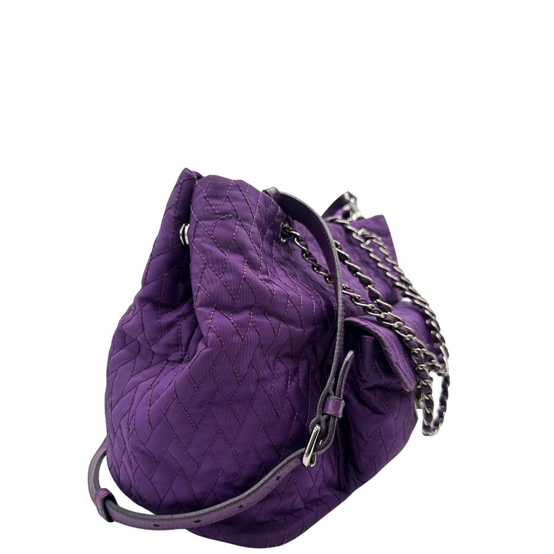 lato Borsa Prada in nylon viola con finiture in pelle tono su tono e parti metalliche argentate; munita di doppi manici in catena e pelle intrecciati e una tracolla amovibile e regolabile. Completa di dustbag, di lusso, originale, ottime condizioni, usata, originale. 