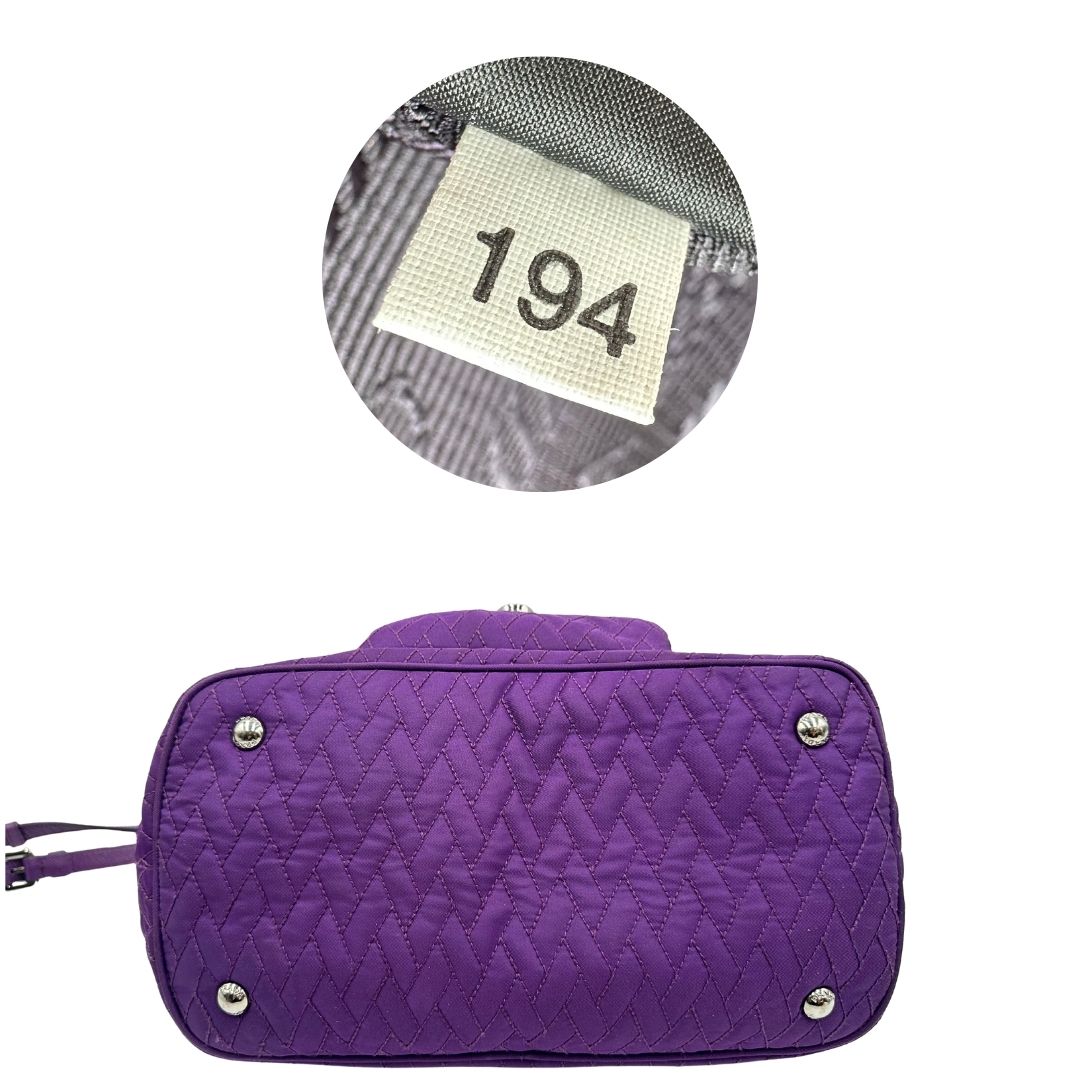 base Borsa Prada in nylon viola con finiture in pelle tono su tono e parti metalliche argentate; munita di doppi manici in catena e pelle intrecciati e una tracolla amovibile e regolabile. Completa di dustbag, di lusso, originale, ottime condizioni, usata, originale. 