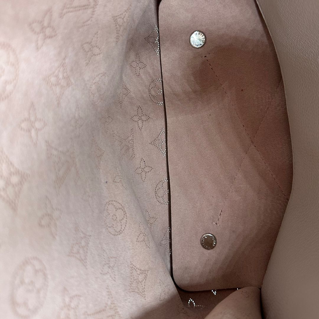 interno Borsa Louis Vuitton in pelle Mahina color grigio Galet con perforature a motivo monogram e parti metalliche argentate, munita di un manico intrecciato e una tracolla amovibile e regolabile; impreziosita da portachiavi e porta address. Completa di corredo, chiavi e lucchetto, di lusso, originale, usata. 