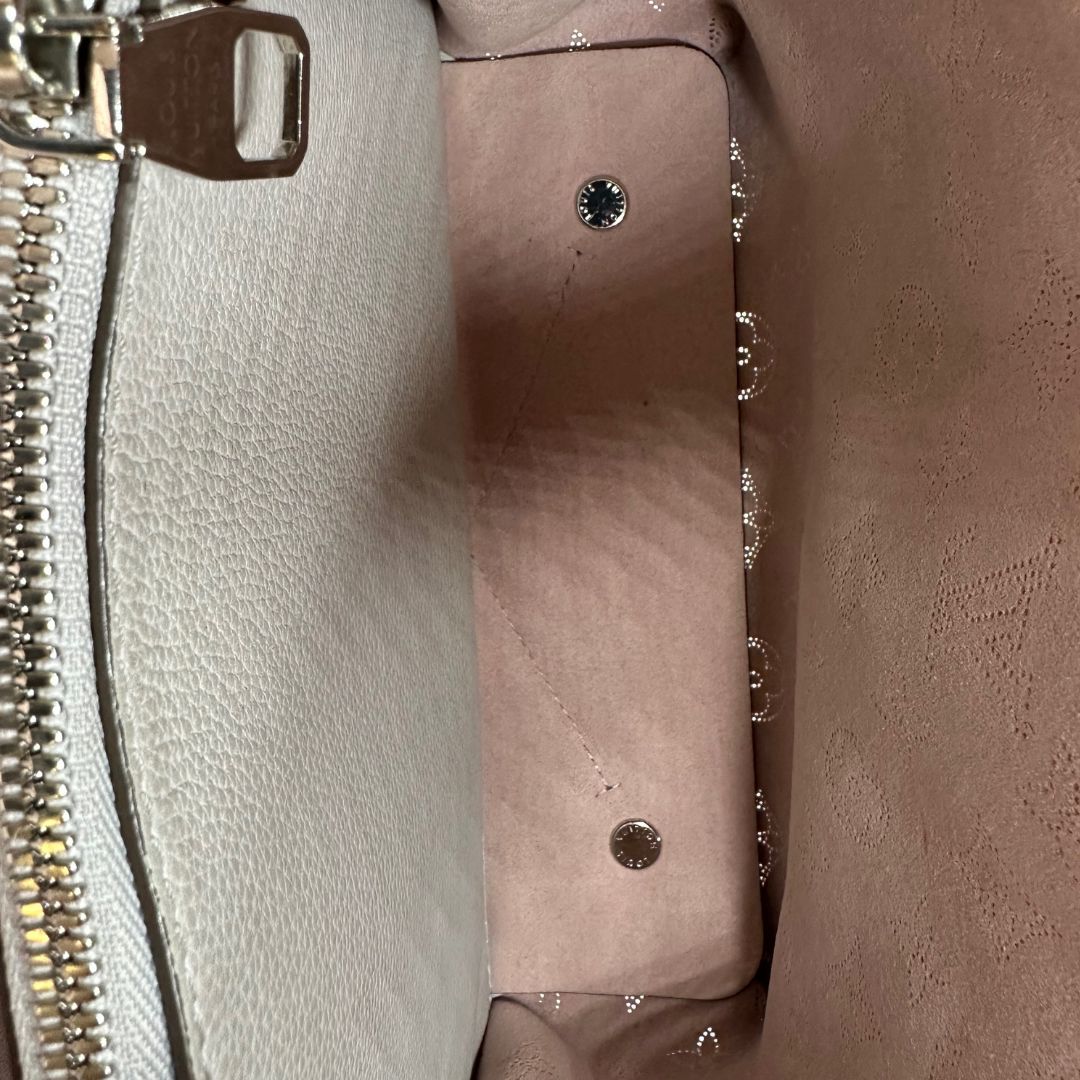 interno Borsa Louis Vuitton in pelle Mahina color grigio Galet con perforature a motivo monogram e parti metalliche argentate, munita di un manico intrecciato e una tracolla amovibile e regolabile; impreziosita da portachiavi e porta address. Completa di corredo, chiavi e lucchetto, di lusso, originale, usata. 