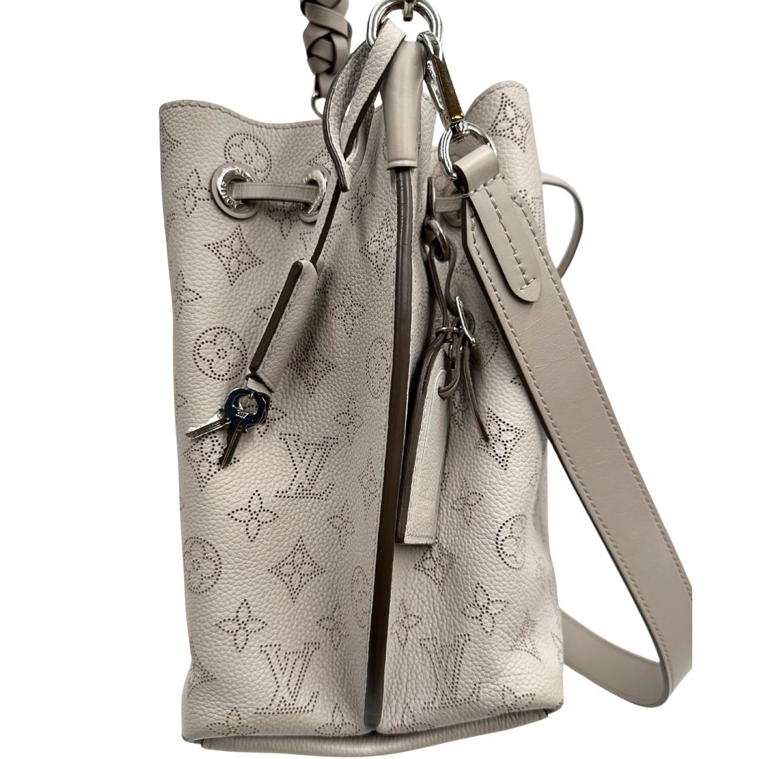 lato Borsa Louis Vuitton in pelle Mahina color grigio Galet con perforature a motivo monogram e parti metalliche argentate, munita di un manico intrecciato e una tracolla amovibile e regolabile; impreziosita da portachiavi e porta address. Completa di corredo, chiavi e lucchetto, di lusso, originale, usata. 