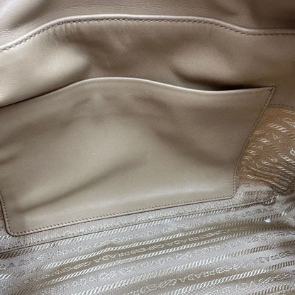 interno della Borsa Prada in nylon beige con finiture in pelle tono su tono e parti metalliche dorate; munita di doppi manici sottili e stondati, indossabile a spalla. Completa di chiavi, lucchetto, cartellini e dustbag, di lusso, originale, ottime condizioni.  