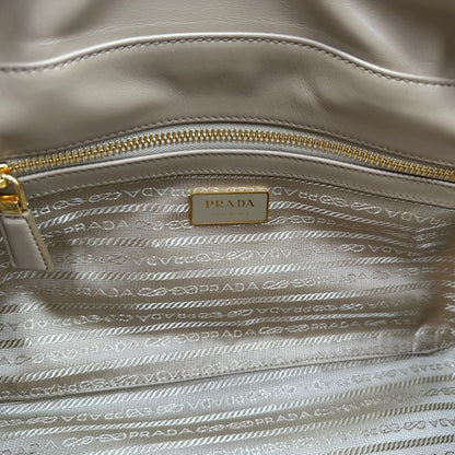 interno della Borsa Prada in nylon beige con finiture in pelle tono su tono e parti metalliche dorate; munita di doppi manici sottili e stondati, indossabile a spalla. Completa di chiavi, lucchetto, cartellini e dustbag, di lusso, originale, ottime condizioni.  