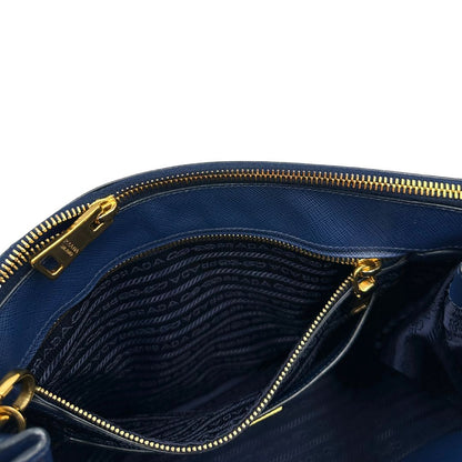 interno Borsa Prada in pelle saffiano blu con parti metalliche dorate; munita di doppi manici stondati, una tracolla amovibile e regolabile e impreziosita da un portachiavi, usata, originale, ottime condizioni. 