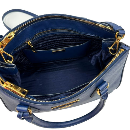 interno Borsa Prada in pelle saffiano blu con parti metalliche dorate; munita di doppi manici stondati, una tracolla amovibile e regolabile e impreziosita da un portachiavi, usata, originale, ottime condizioni.