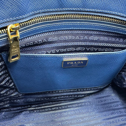 interno Borsa Prada in pelle saffiano blu con parti metalliche dorate; munita di doppi manici stondati, una tracolla amovibile e regolabile e impreziosita da un portachiavi, usata, originale, ottime condizioni. 