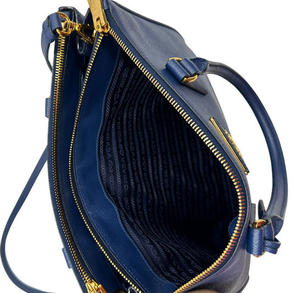 interno Borsa Prada in pelle saffiano blu con parti metalliche dorate; munita di doppi manici stondati, una tracolla amovibile e regolabile e impreziosita da un portachiavi, usata, originale, ottime condizioni.