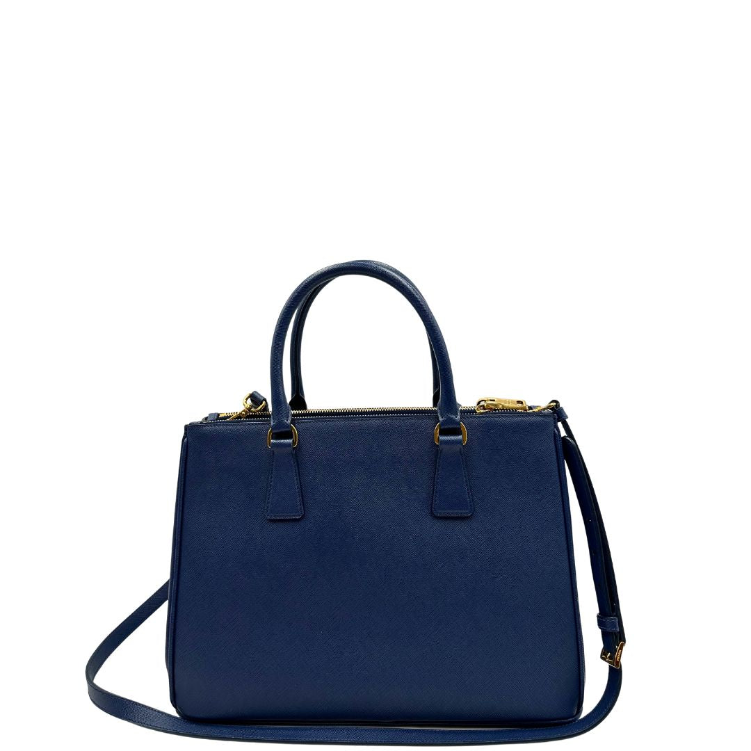 retro Borsa Prada in pelle saffiano blu con parti metalliche dorate; munita di doppi manici stondati, una tracolla amovibile e regolabile e impreziosita da un portachiavi, usata, originale, ottime condizioni. 