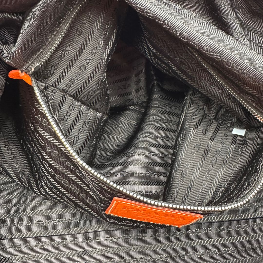 interno Borsone Prada in nylon arancione con finiture in pelle tono su tono e parti metalliche argentate; munita di doppi manici stondati e una tracolla leggermente regolabile, di lusso, originale, ottime condizioni, usata. 