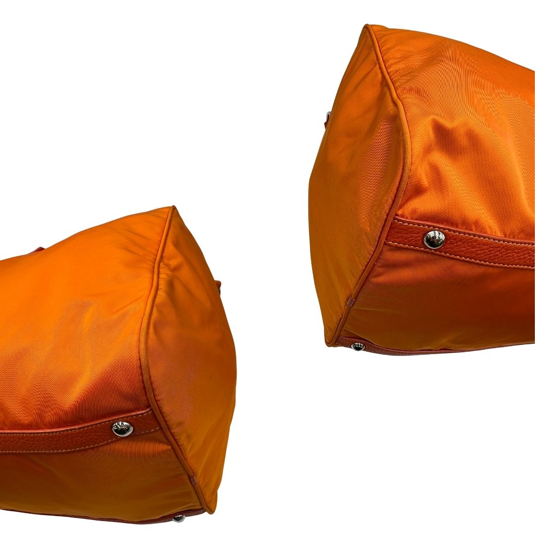 angoli Borsone Prada in nylon arancione con finiture in pelle tono su tono e parti metalliche argentate; munita di doppi manici stondati e una tracolla leggermente regolabile, di lusso, originale, ottime condizioni, usata. 