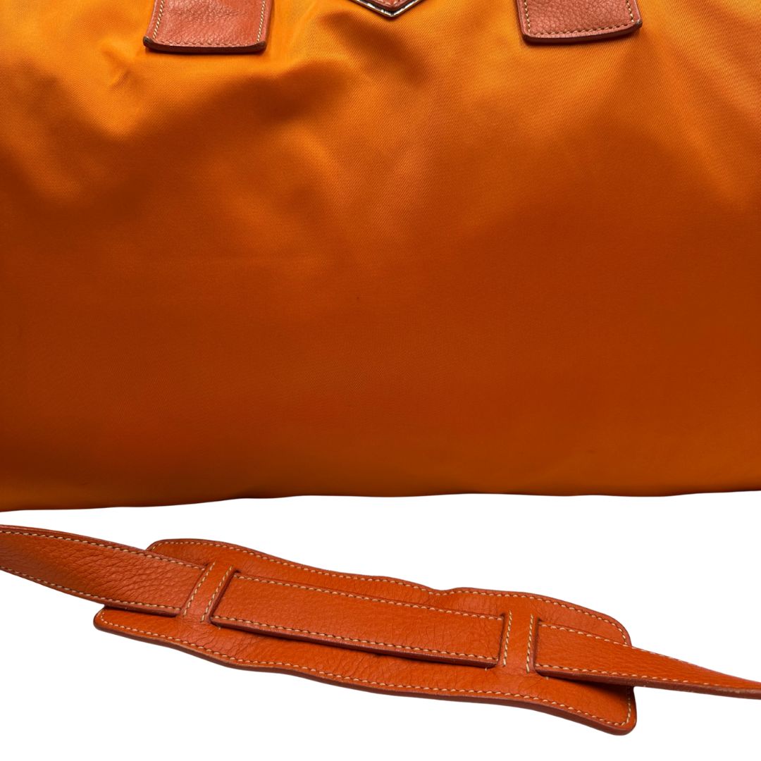 Borsone Prada in nylon arancione con finiture in pelle tono su tono e parti metalliche argentate; munita di doppi manici stondati e una tracolla leggermente regolabile, di lusso, originale, ottime condizioni, usata. 