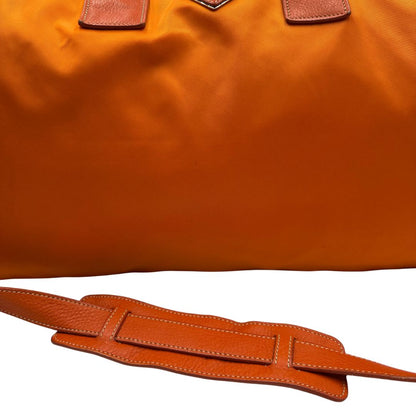 Borsone Prada in nylon arancione con finiture in pelle tono su tono e parti metalliche argentate; munita di doppi manici stondati e una tracolla leggermente regolabile, di lusso, originale, ottime condizioni, usata. 