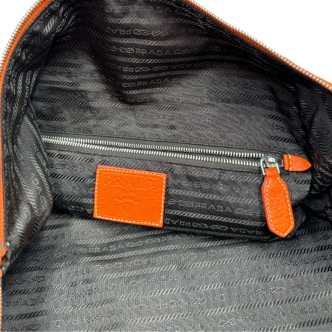 interno Borsone Prada in nylon arancione con finiture in pelle tono su tono e parti metalliche argentate; munita di doppi manici stondati e una tracolla leggermente regolabile, di lusso, originale, ottime condizioni, usata. 