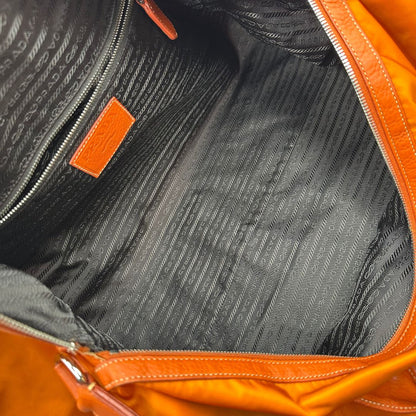 interno Borsone Prada in nylon arancione con finiture in pelle tono su tono e parti metalliche argentate; munita di doppi manici stondati e una tracolla leggermente regolabile, di lusso, originale, ottime condizioni, usata. 