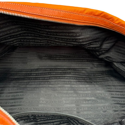 interno Borsone Prada in nylon arancione con finiture in pelle tono su tono e parti metalliche argentate; munita di doppi manici stondati e una tracolla leggermente regolabile, di lusso, originale, ottime condizioni, usata. 