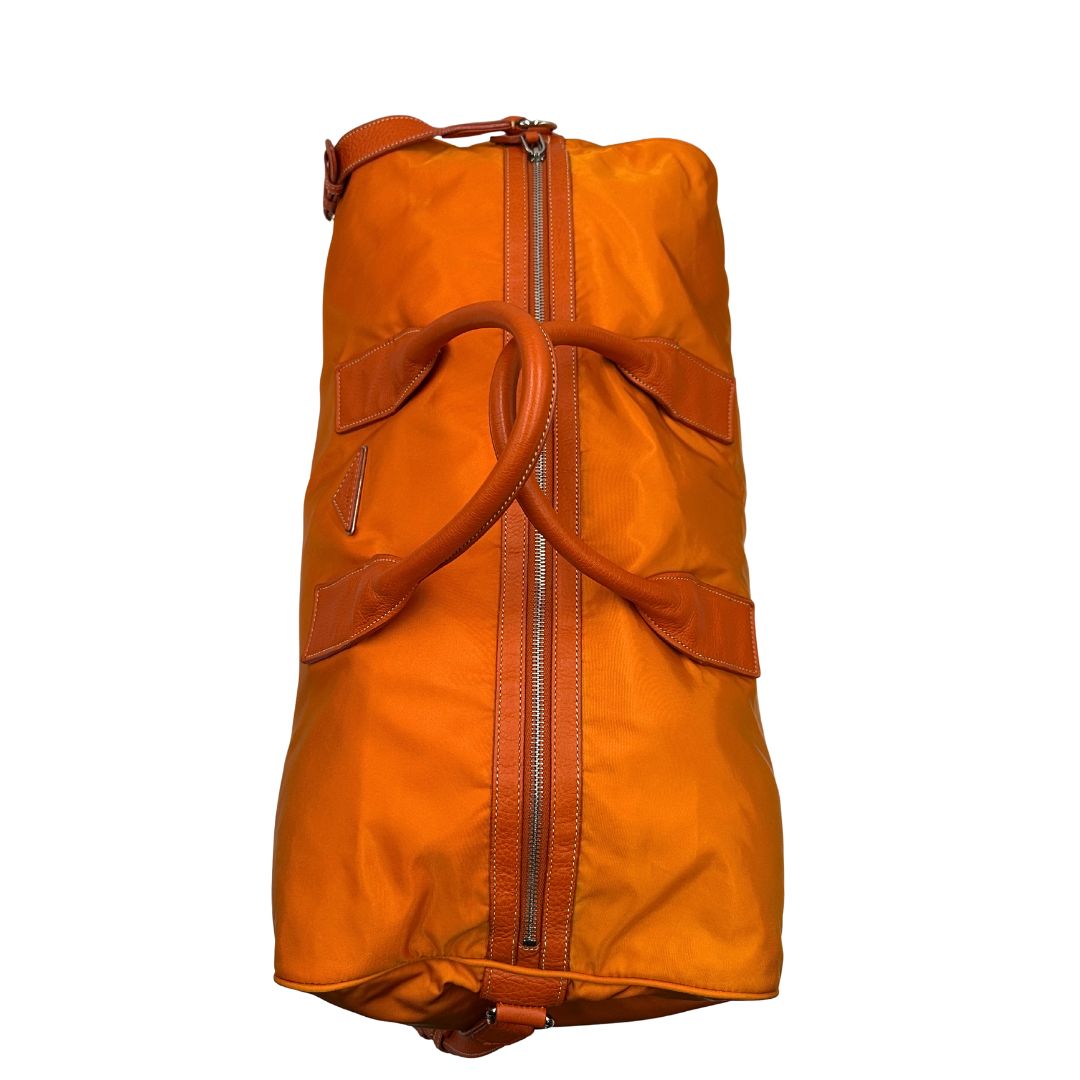 manici Borsone Prada in nylon arancione con finiture in pelle tono su tono e parti metalliche argentate; munita di doppi manici stondati e una tracolla leggermente regolabile, di lusso, originale, ottime condizioni, usata. 