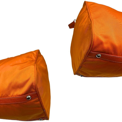 angoli Borsone Prada in nylon arancione con finiture in pelle tono su tono e parti metalliche argentate; munita di doppi manici stondati e una tracolla leggermente regolabile, di lusso, originale, ottime condizioni, usata. 