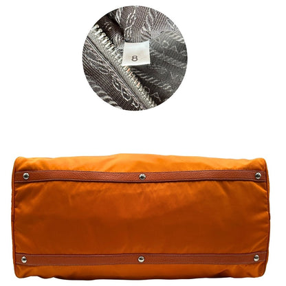 base Borsone Prada in nylon arancione con finiture in pelle tono su tono e parti metalliche argentate; munita di doppi manici stondati e una tracolla leggermente regolabile, di lusso, originale, ottime condizioni, usata.