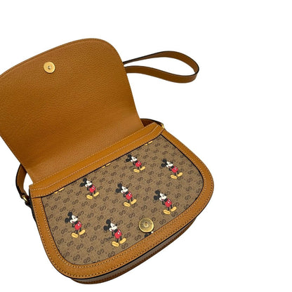 chiusura Borsa Gucci  in canvas GG mini marrone con finiture in pelle tono su tono e parti metalliche dorate; stampa di topolino sul canvas, munita di una tracolla regolabile. Completa di dustbag, di lusso, eccellenti condizioni, usata. 