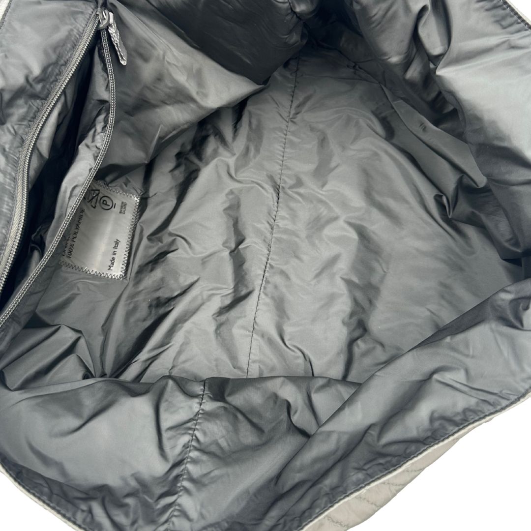 interno Borsa Prada in nylon grigio trapuntato con motivo ondulato, munita di doppi manici in tessuto tono su tono; indossabile a spalla, di lusso, originale, ottime condizioni. 