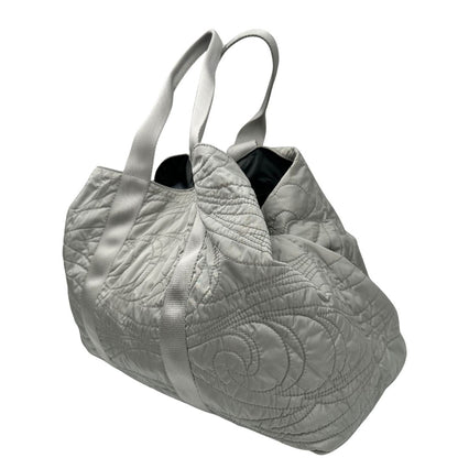 lato Borsa Prada in nylon grigio trapuntato con motivo ondulato, munita di doppi manici in tessuto tono su tono; indossabile a spalla, di lusso, originale, ottime condizioni. 