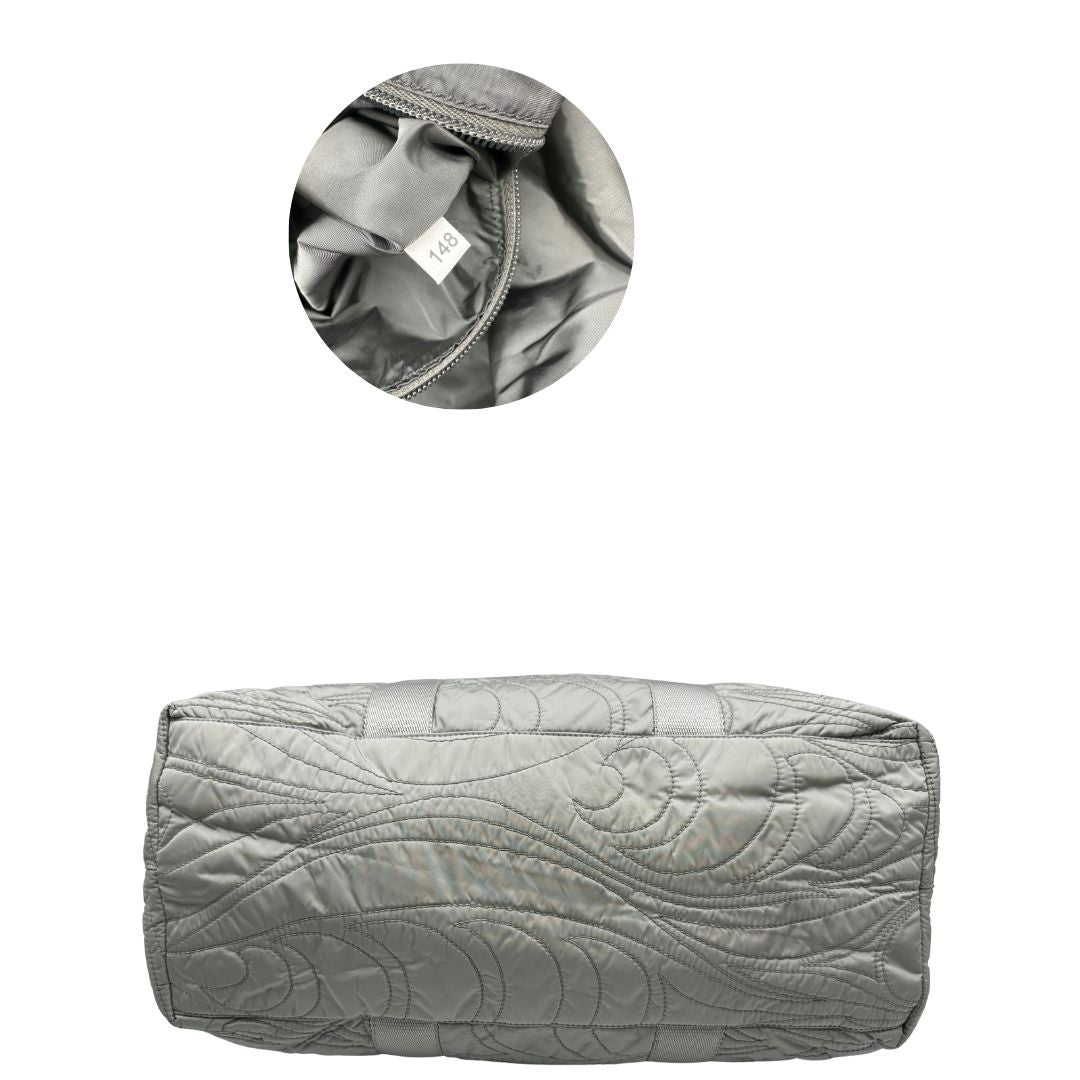 base Borsa Prada in nylon grigio trapuntato con motivo ondulato, munita di doppi manici in tessuto tono su tono; indossabile a spalla, di lusso, originale, ottime condizioni. 