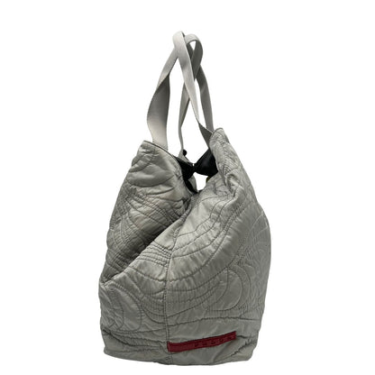 lato Borsa Prada in nylon grigio trapuntato con motivo ondulato, munita di doppi manici in tessuto tono su tono; indossabile a spalla, di lusso, originale, ottime condizioni. 