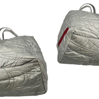 angoli Borsa Prada in nylon grigio trapuntato con motivo ondulato, munita di doppi manici in tessuto tono su tono; indossabile a spalla, di lusso, originale, ottime condizioni. 