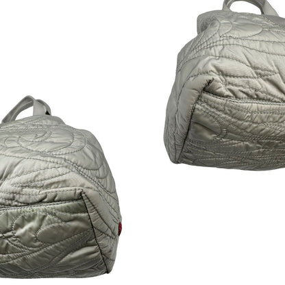 angoli Borsa Prada in nylon grigio trapuntato con motivo ondulato, munita di doppi manici in tessuto tono su tono; indossabile a spalla, di lusso, originale, ottime condizioni. 