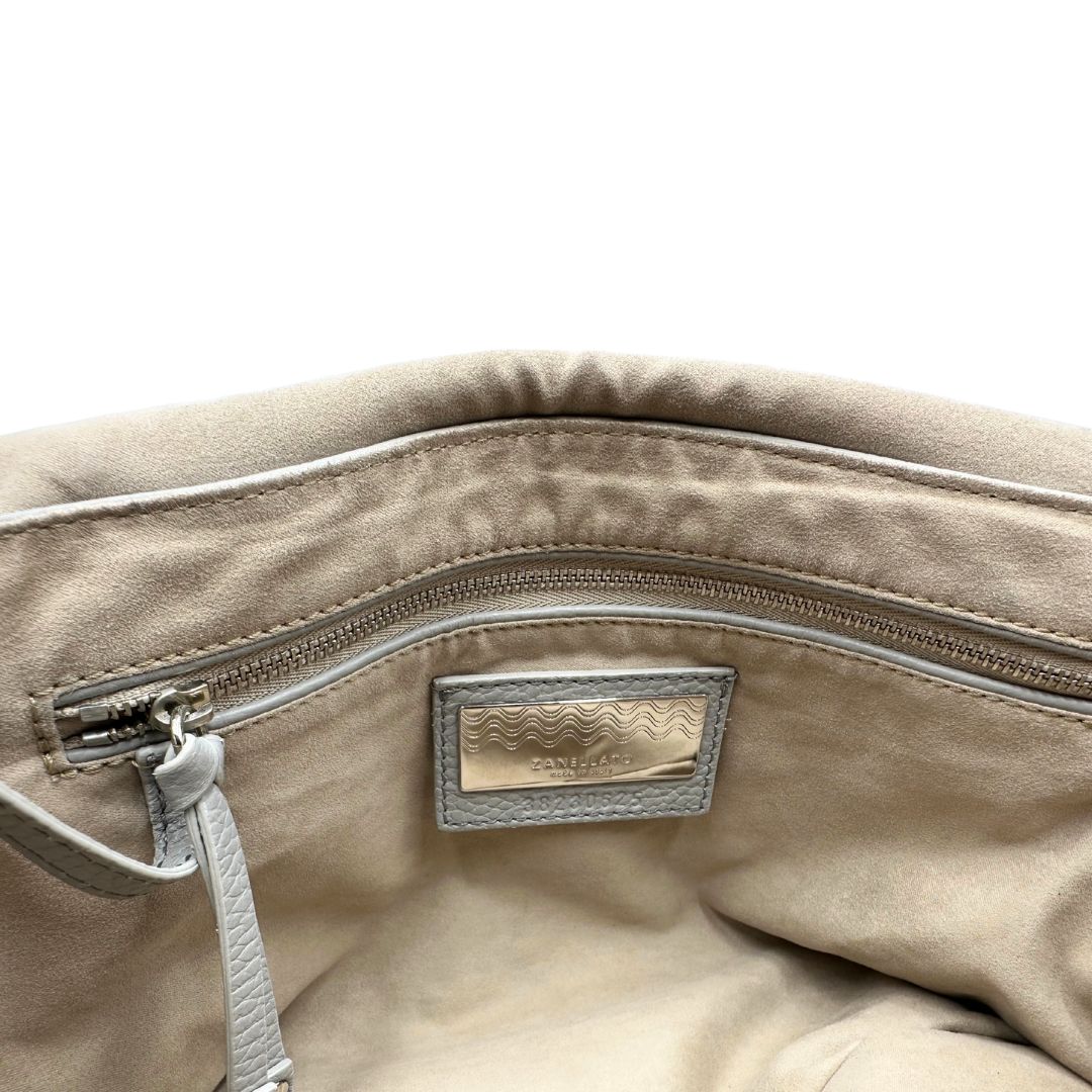 Interno di una borsa Zanellato in pelle martellata grigio chiaro, parti con metalliche argentate; munita di un manico singolo, tracolla amovibile e regolabile. Completa di dustbag.
