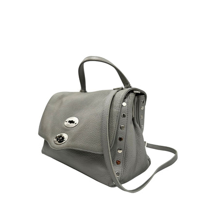 Laterale destro di una borsa Zanellato in pelle martellata grigio chiaro, parti con metalliche argentate; munita di un manico singolo, tracolla amovibile e regolabile. Completa di dustbag.