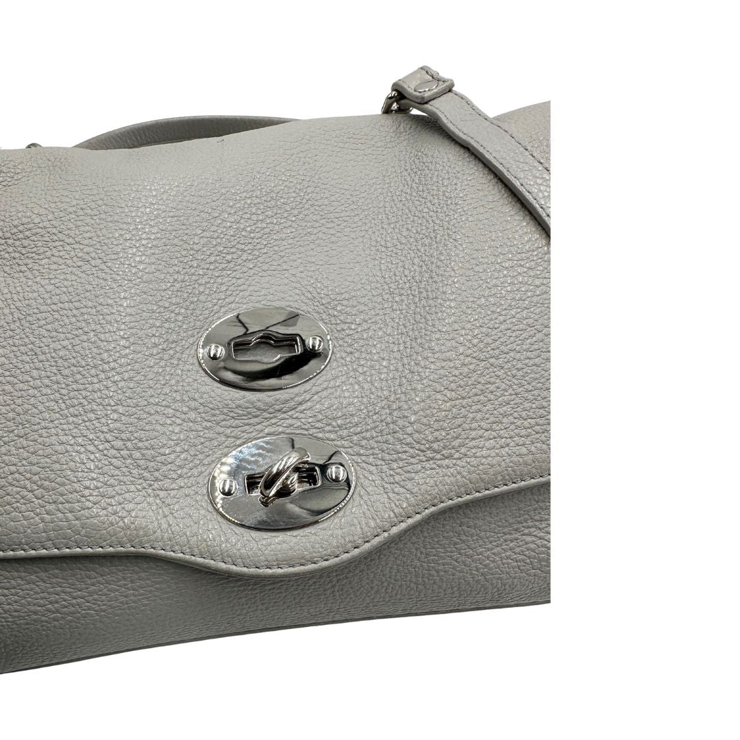 Chiusura di una borsa Zanellato in pelle martellata grigio chiaro, parti con metalliche argentate; munita di un manico singolo, tracolla amovibile e regolabile. Completa di dustbag.