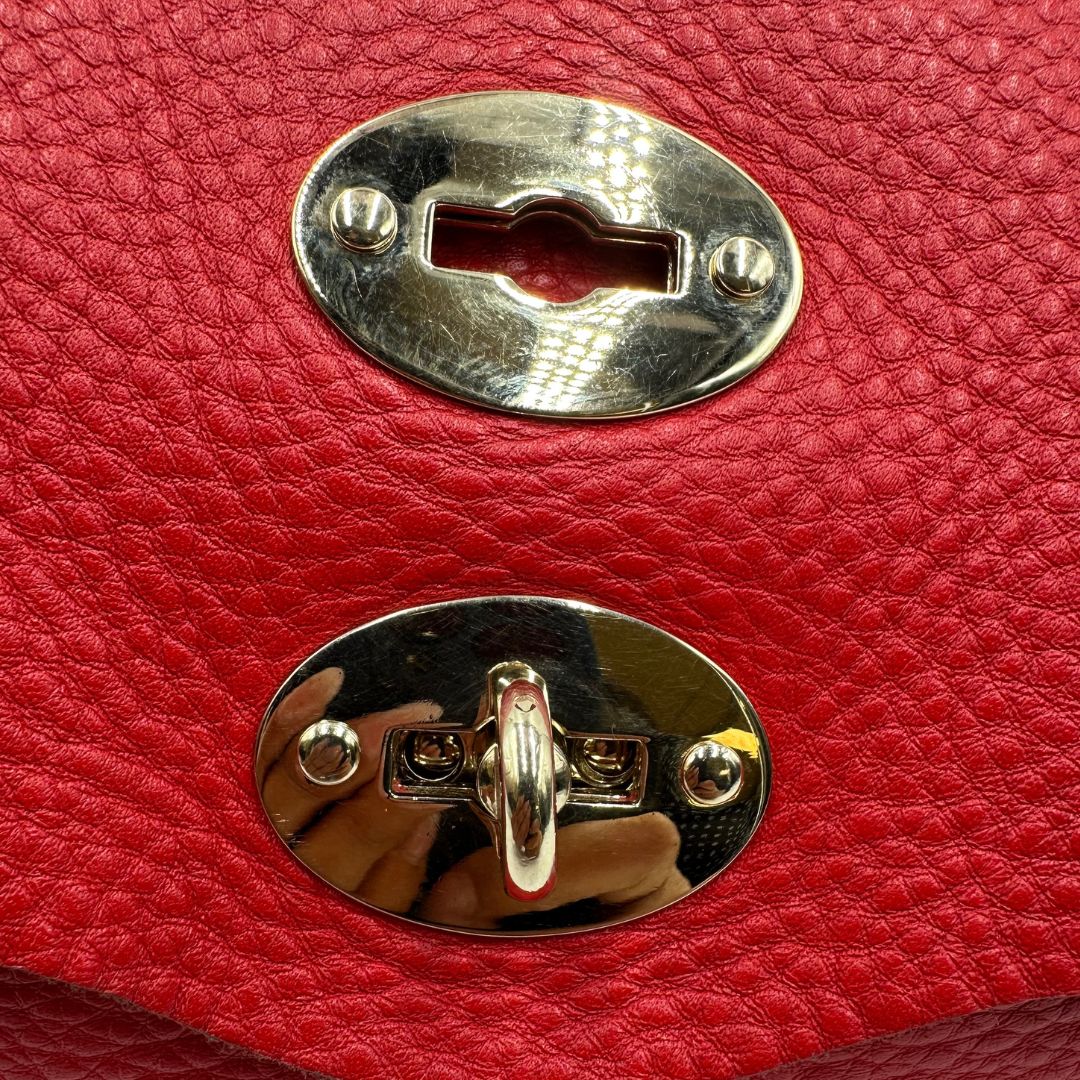chiusura Borsa Zanellato in pelle martellata rossa con parti metalliche dorate; munita di un manico singolo e una tracolla amovibile e regolabile. Completa di dustbag, di lusso, originale, ottime condizioni, usata. 