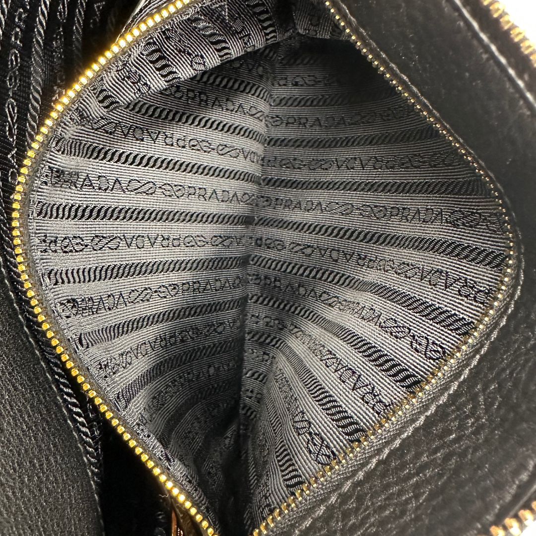 interno Borsa Prada in pelle martellata nera con parti metalliche dorate; munita di una tracolla amovibile e regolabile, da portare a mano, a spalla o a tracolla. Completa di dustbag, di lusso, originale, eccellenti condizioni, usata. 