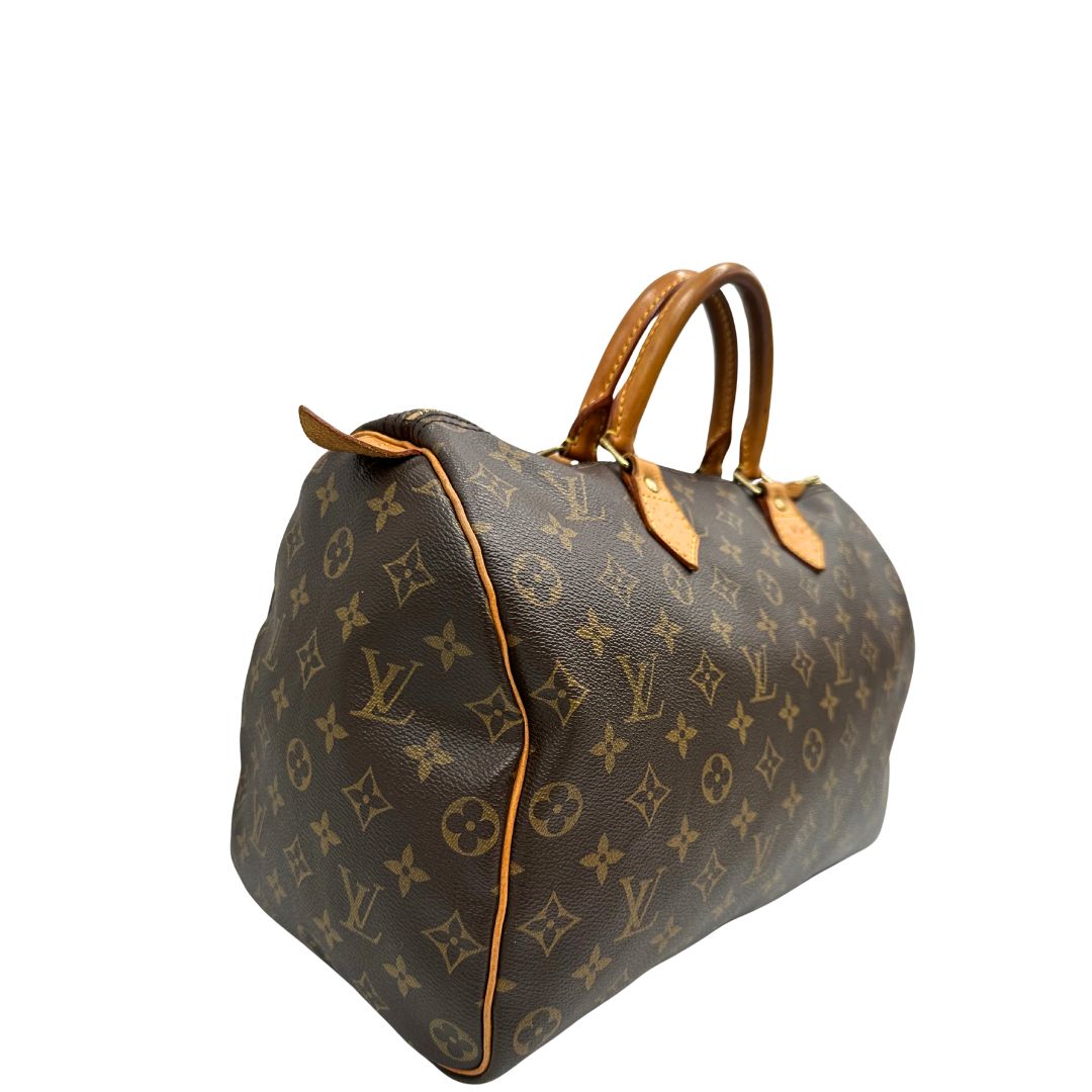 lato Borsa Louis Vuitton in canvas monogram marrone con parti metalliche dorate; munita di doppi manici stondati, da portare a mano. Completa di dustbag, lucchetto e chiavi, di lusso, usato, ottime condizioni. 