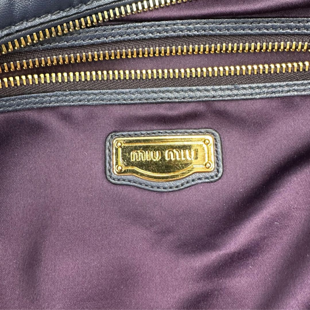 interno Borsa Miu Miu in pelle blu con parti metalliche dorate; munita di una tracolla amovibile e doppi manici stondati. Completa di dustbag, di lusso, originale, ottime condizioni. 