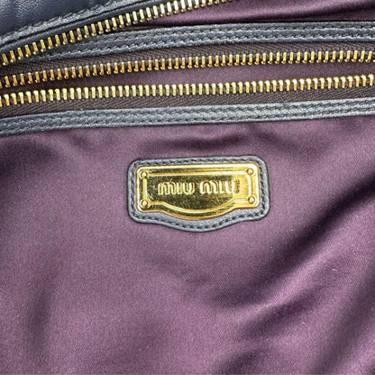 interno Borsa Miu Miu in pelle blu con parti metalliche dorate; munita di una tracolla amovibile e doppi manici stondati. Completa di dustbag, di lusso, originale, ottime condizioni. 