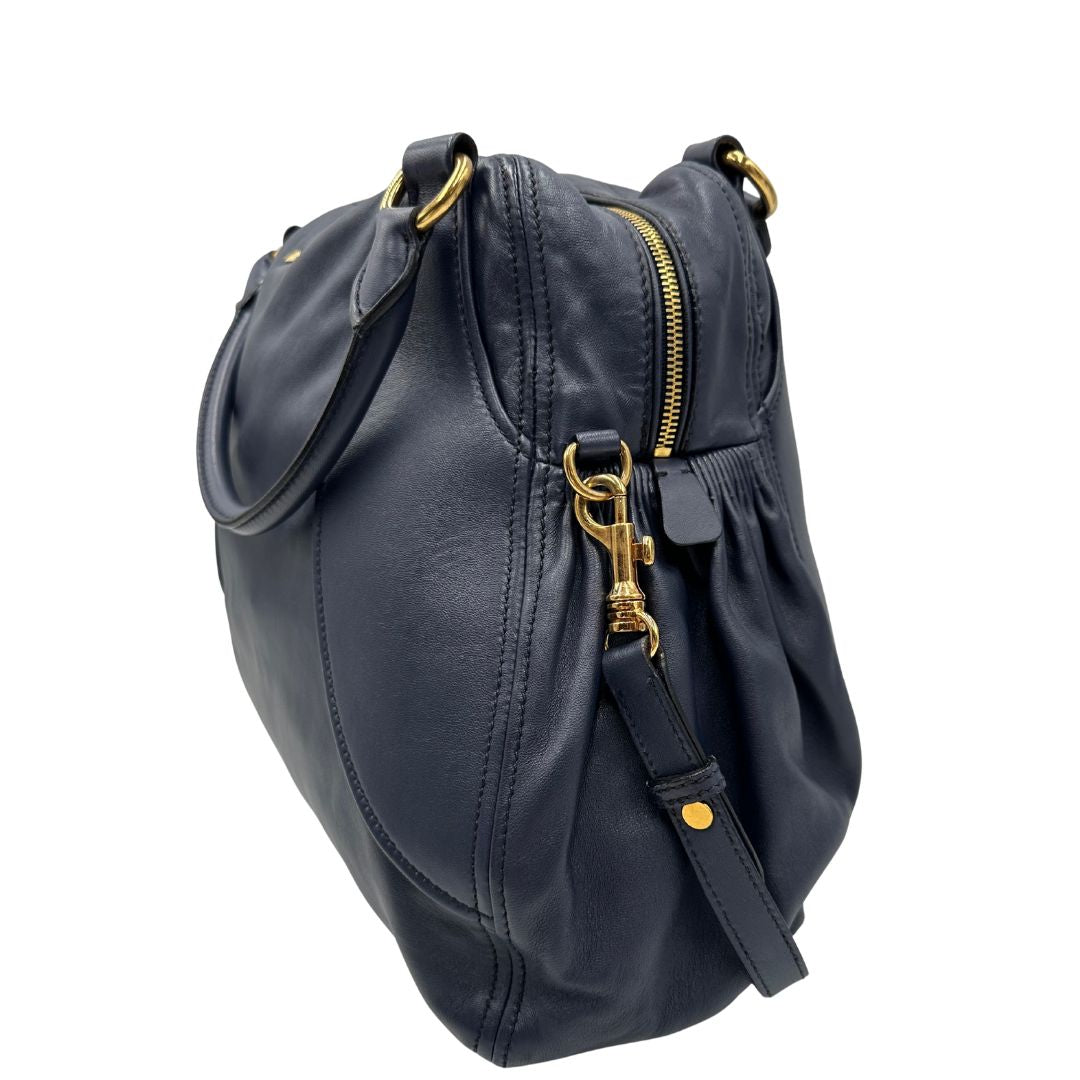 lato Borsa Miu Miu in pelle blu con parti metalliche dorate; munita di una tracolla amovibile e doppi manici stondati. Completa di dustbag, di lusso, originale, ottime condizioni. 